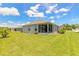 Large backyard featuring a well-manicured lawn and a screened patio at 2836 Monaghan Dr, Ormond Beach, FL 32174