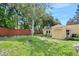 Cozy backyard with a private wooden fence, lush lawn, and mature trees, an ideal space for outdoor activities at 918 N Wild Olive Ave, Daytona Beach, FL 32118