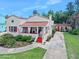 Charming single-story home featuring a beautiful red tile roof, covered porch, and meticulously maintained landscaping at 918 N Wild Olive Ave, Daytona Beach, FL 32118