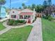 Charming single-story home featuring a beautiful red tile roof, covered porch, and meticulously maintained landscaping at 918 N Wild Olive Ave, Daytona Beach, FL 32118