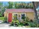 Charming home with a red door, well-manicured landscaping, and vibrant flowers at 918 N Wild Olive Ave, Daytona Beach, FL 32118