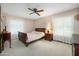 Bedroom with carpet, ceiling fan, matching nightstands and side tables, and natural light from two windows at 1108 Northside Dr, Ormond Beach, FL 32174
