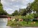 Brick home with a green lawn, mature trees, and a two deer in the front yard at 1108 Northside Dr, Ormond Beach, FL 32174