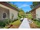 A front porch with a bench, green plants and flowers along a walkway to the front door at 1108 Northside Dr, Ormond Beach, FL 32174