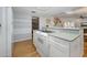 Bright kitchen with white cabinetry, stainless appliances, hardwood floors, and a breakfast bar at 1108 Northside Dr, Ormond Beach, FL 32174