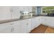 Clean kitchen featuring white cabinets, granite counters, modern appliances, and tile backsplash at 1108 Northside Dr, Ormond Beach, FL 32174
