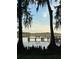 Tranquil waterfront view featuring a wooden dock with seating, framed by trees at 1162 Carmel Cir # 100, Casselberry, FL 32707