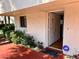 Inviting condo entrance with a red walkway, lush greenery, and a secured front door at 1162 Carmel Cir # 100, Casselberry, FL 32707