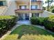 Back of condo with tile roof, bushes and grass at 1162 Carmel Cir # 100, Casselberry, FL 32707