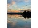 Beautiful lake reflecting a vibrant sunset with trees silhouetted against the horizon at 1162 Carmel Cir # 100, Casselberry, FL 32707