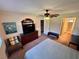 Spacious main bedroom with a ceiling fan, television, bench, and ensuite bathroom at 1162 Carmel Cir # 100, Casselberry, FL 32707