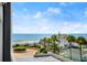 A scenic view from the balcony overlooking palm trees, parking area, and a glimpse of the ocean at 1239 Ocean Shore Blvd # 3C3, Ormond Beach, FL 32176