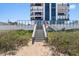Beach access featuring stairs leading to beach next to modern condo building at 1239 Ocean Shore Blvd # 3C3, Ormond Beach, FL 32176