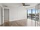 A bright room with wood floor, ceiling fan, and a window looking out at palm trees at 1239 Ocean Shore Blvd # 3C3, Ormond Beach, FL 32176