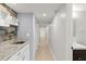 Hallway wet bar featuring stone backsplash, white cabinets, granite countertops and storage cubbies at 1239 Ocean Shore Blvd # 3C3, Ormond Beach, FL 32176