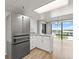 Open-concept kitchen with stainless steel appliances, white cabinets, and hardwood floors at 1239 Ocean Shore Blvd # 3C3, Ormond Beach, FL 32176