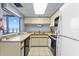 Bright kitchen features tile flooring, wood cabinets, and an ocean view from the window over the countertop at 1239 Ocean Shore Blvd # 3C3, Ormond Beach, FL 32176