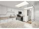 Well-lit kitchen features stainless steel appliances, white cabinets, granite countertops, and laundry access at 1239 Ocean Shore Blvd # 3C3, Ormond Beach, FL 32176