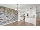 Open living room with stone accent wall and wood flooring at 1239 Ocean Shore Blvd # 3C3, Ormond Beach, FL 32176