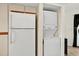 Appliance area featuring a white refrigerator and stacked washer and dryer at 133 Blue Heron Dr # D, Daytona Beach, FL 32119