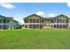 Spacious backyard view featuring a well-maintained lawn and inviting screened-in porches at 133 Blue Heron Dr # D, Daytona Beach, FL 32119