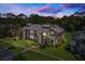 Aerial view of a two-story townhome with lush landscaping, trees, and a beautiful evening sky at 133 Blue Heron Dr # D, Daytona Beach, FL 32119