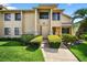 Inviting two-story condo with well-maintained landscaping and walkway leading to the front door at 133 Blue Heron Dr # D, Daytona Beach, FL 32119