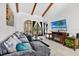 Cozy living room featuring vaulted ceilings, wooden beams, comfortable seating, and a decorative fireplace at 133 Blue Heron Dr # D, Daytona Beach, FL 32119