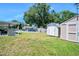 Spacious backyard with a covered patio, pool, and storage sheds at 1505 Valencia Ave, Daytona Beach, FL 32117