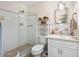 Bright bathroom with a glass-enclosed shower, neutral tile, and updated vanity featuring a stone countertop at 1505 Valencia Ave, Daytona Beach, FL 32117
