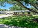Charming single-story home with yellow siding, brick accents, well-manicured lawn, mature trees, and an attached two-car garage at 1505 Valencia Ave, Daytona Beach, FL 32117