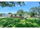 Charming single-story home with yellow siding, brick accents, well-manicured lawn, mature trees, and an attached two-car garage at 1505 Valencia Ave, Daytona Beach, FL 32117