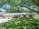Charming single-story home with yellow siding, brick accents, well-manicured lawn, mature trees, and an attached two-car garage at 1505 Valencia Ave, Daytona Beach, FL 32117
