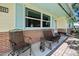 Cozy front porch with seating, brick accents, yellow siding, and light blue shutters, offering a welcoming curb appeal at 1505 Valencia Ave, Daytona Beach, FL 32117