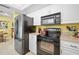 Kitchen area showing stainless steel refrigerator and oven, plus a black microwave at 1505 Valencia Ave, Daytona Beach, FL 32117