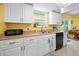 Well-lit kitchen featuring white cabinetry, stainless steel sink, and views of the dining area at 1505 Valencia Ave, Daytona Beach, FL 32117