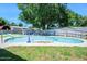 Backyard pool is surrounded by a concrete deck and grass and has mature trees providing shade at 1505 Valencia Ave, Daytona Beach, FL 32117