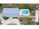 A top-down view of a home shows a swimming pool, patio furniture, a driveway, and a well-maintained yard at 209 Falcon Ave, Edgewater, FL 32141