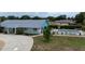 A backyard featuring a pool with lounge chairs, manicured lawn, privacy hedges, and a concrete patio at 209 Falcon Ave, Edgewater, FL 32141