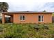Backyard view of the home with two windows and outdoor features at 209 Falcon Ave, Edgewater, FL 32141