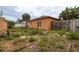 Home's exterior backyard showcasing a compact yard, wooden fence, and small windows along the back wall at 209 Falcon Ave, Edgewater, FL 32141