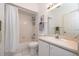 Clean, white bathroom featuring a shower-tub combo, toilet, and vanity with ample lighting at 209 Falcon Ave, Edgewater, FL 32141