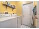 Functional laundry room with a washer, dryer, and storage shelf at 209 Falcon Ave, Edgewater, FL 32141