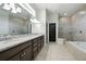 A modern bathroom features dual sinks, granite countertop, and walk-in glass shower and soaking tub at 3048 Borassus Dr, New Smyrna Beach, FL 32168
