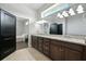Bright bathroom featuring dual sinks and granite countertop with an adjacent bedroom and walk-in closet at 3048 Borassus Dr, New Smyrna Beach, FL 32168