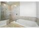 Luxurious bathroom featuring a soaking tub with tiled walls and glass enclosed shower at 3048 Borassus Dr, New Smyrna Beach, FL 32168