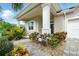 Close-up of a home's entrance, highlighting a charming stone walkway, lush landscaping, and inviting curb appeal at 3048 Borassus Dr, New Smyrna Beach, FL 32168