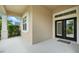 Inviting covered entrance featuring stylish black double doors and sleek white columns, adding to the home's appeal at 3048 Borassus Dr, New Smyrna Beach, FL 32168