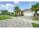 Inviting single-story home with a paver driveway, lush landscaping, and a spacious two-car garage at 3048 Borassus Dr, New Smyrna Beach, FL 32168