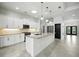 Modern kitchen with white cabinets, granite countertops, stainless steel appliances, and a central island at 3048 Borassus Dr, New Smyrna Beach, FL 32168